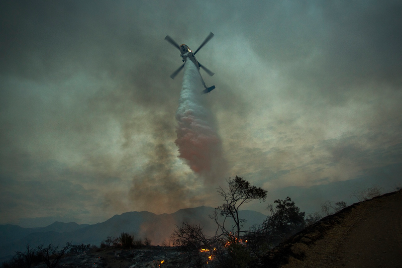 A firefighting helicopter drops water in the evening at the La Tuna Fire on September 2, 2017 near Burbank, California. (Photo by David McNew/Getty Images)